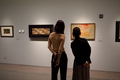 The woman dressed in black stand next to the woman in white long-sleeved clothes
